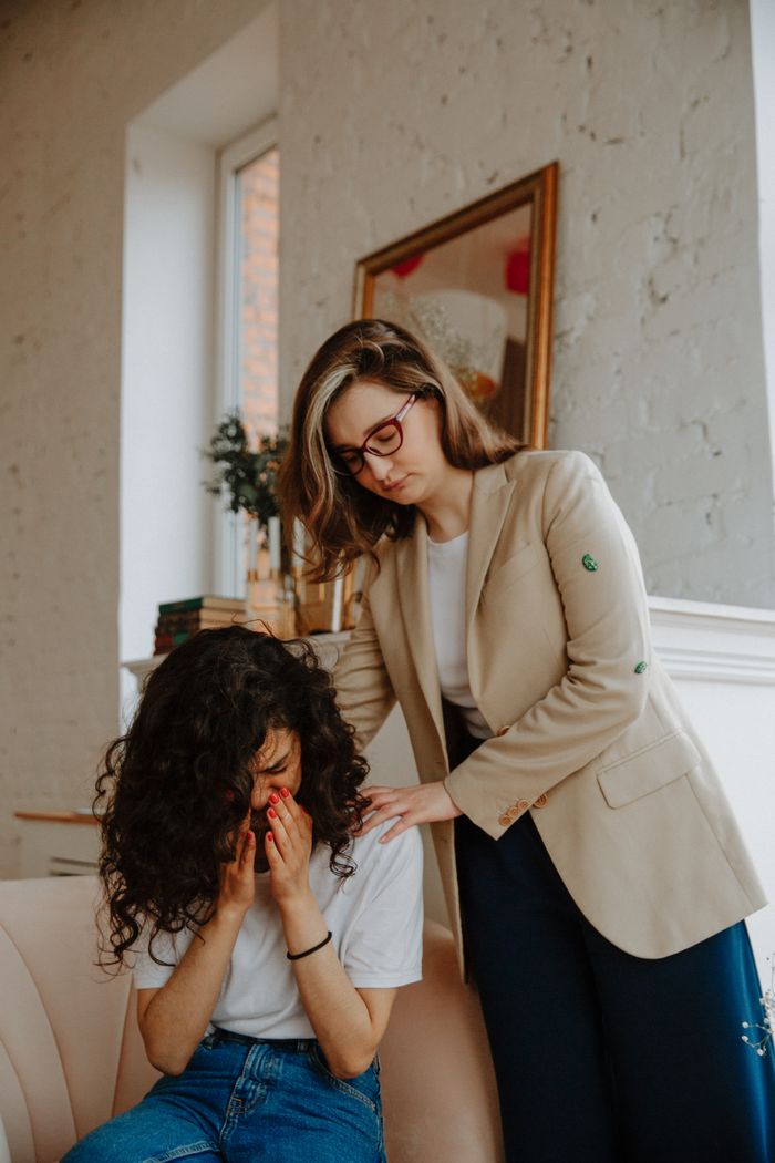A compassionate therapy session with a therapist comforting a distressed woman.