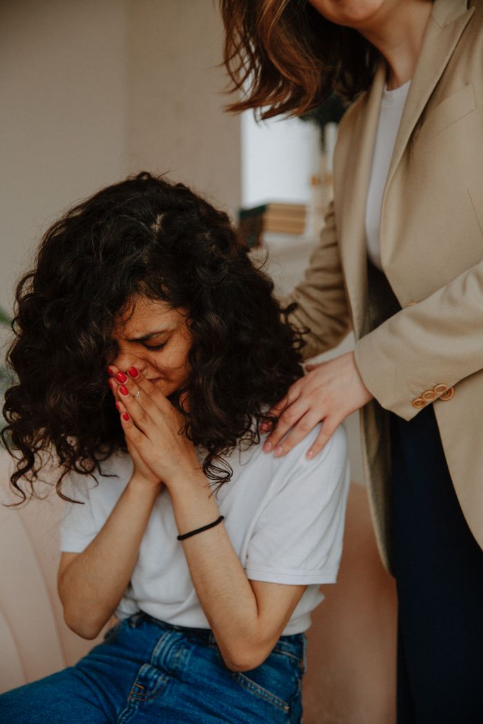 A young woman receives comforting support in a counseling session, highlighting empathy and mental health awareness.