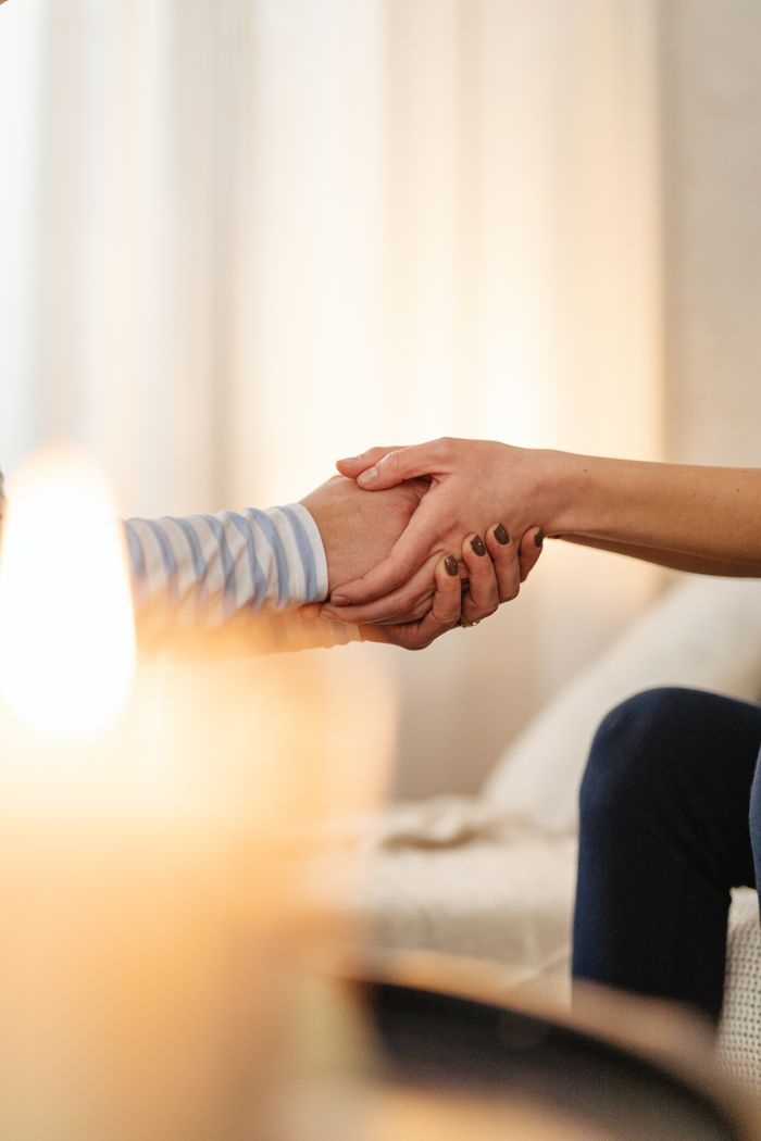 A comforting handshake with candles symbolizing care and empathy.